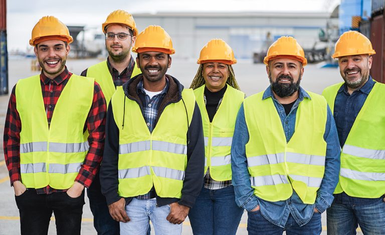 Team coaching in action with multiracial professionals collaborating at an industrial port