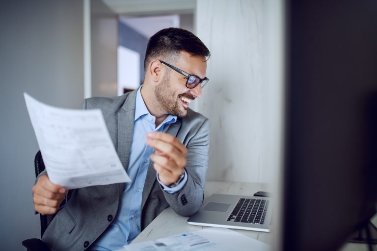 Attractive smiling unshaven caucasian businessman in suit, happy because he is in business development training