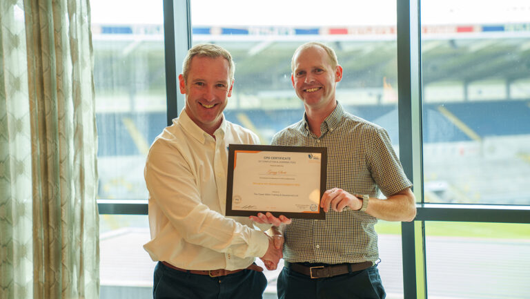 Managing with MQ graduate from Caddick, smiling and holding his certificate next to trainer Alan after completing the programme.