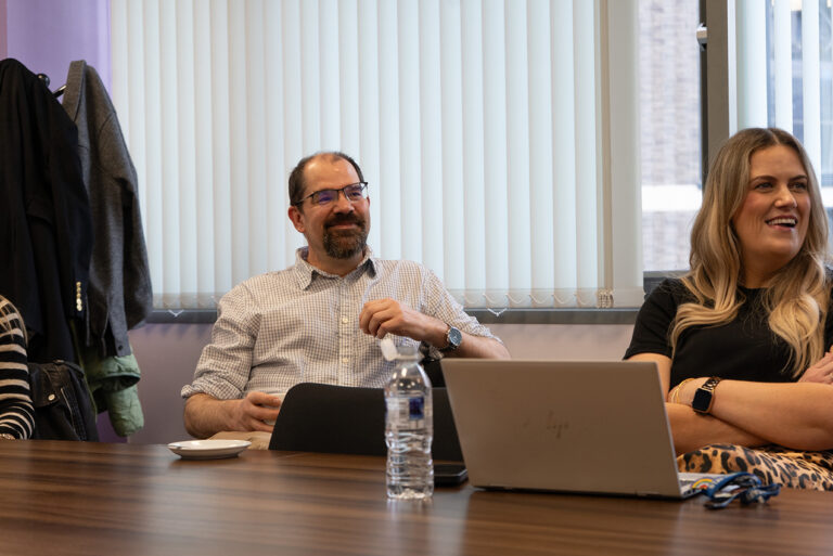 Client sitting around a boardroom table enjoying and engaging with the Growth Leadership Programme training session.