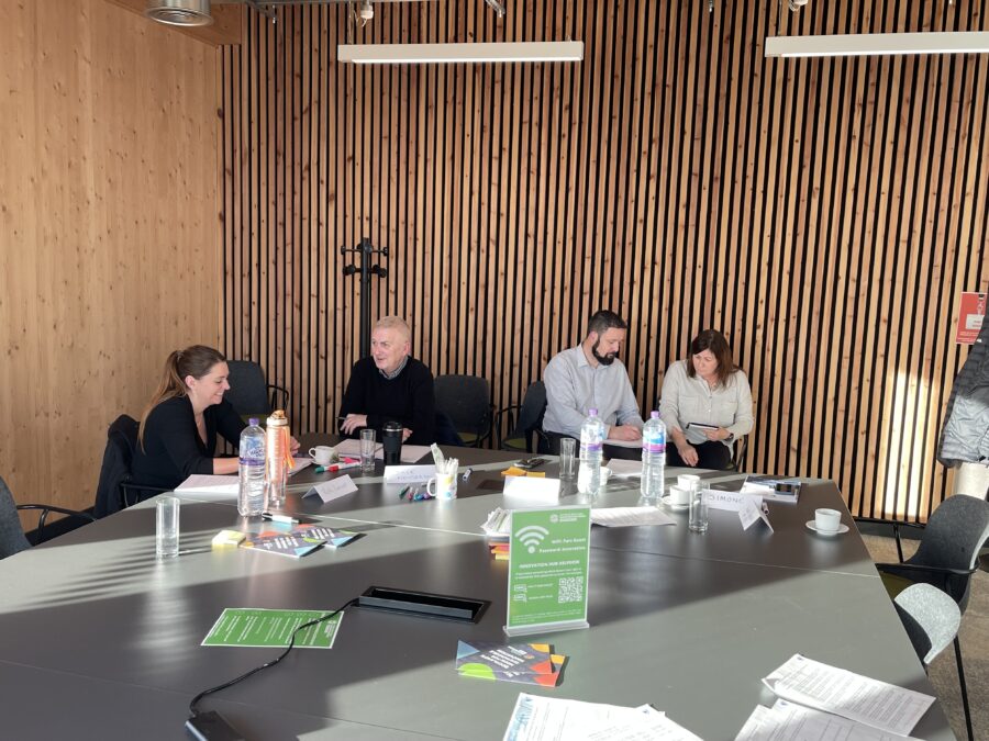 Boardroom group enjoying an interactive leading with change coaching session, showing connection and engagement with the content.