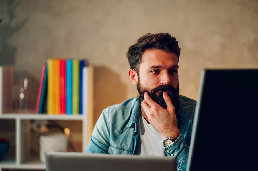Mental Health awareness programme, hero image of a man concerned, deeply thinking, holding his beard